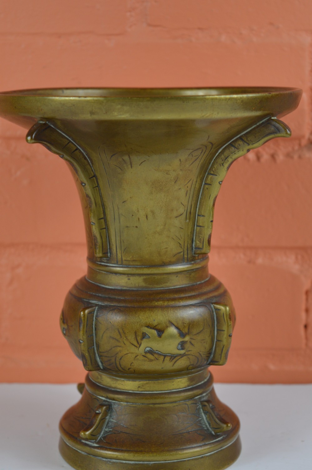 A cast bronze trumpet-shaped Chinese Gu vase with vertical flanges, a bulbous central section, and incised archaic pattern detailing. View IV