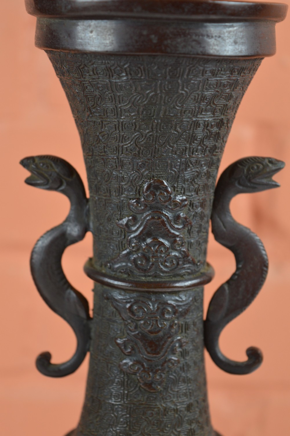 A pair of dark brown patinated Japanese bronze vases featuring dragon-form handles and relief panels depicting birds amongst aquatic foliage. View IX