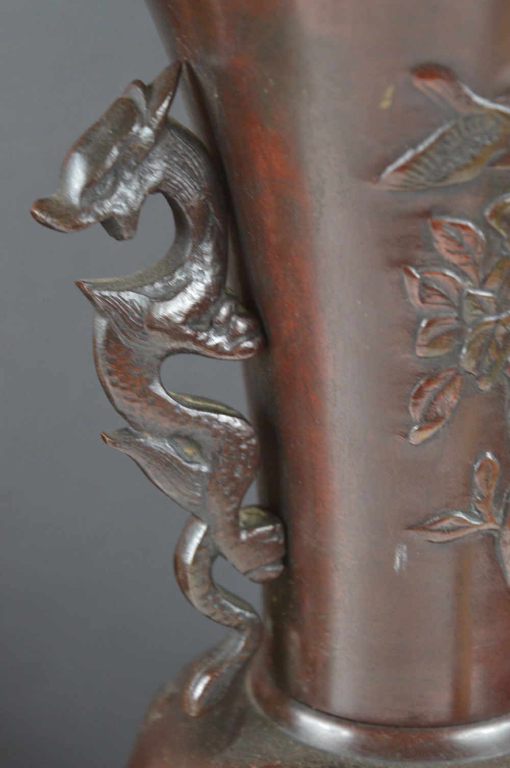 A cast dark bronze baluster vase featuring dragon-form side handles, a flared rim, and relief carvings of birds perched on flowering branches. View IV