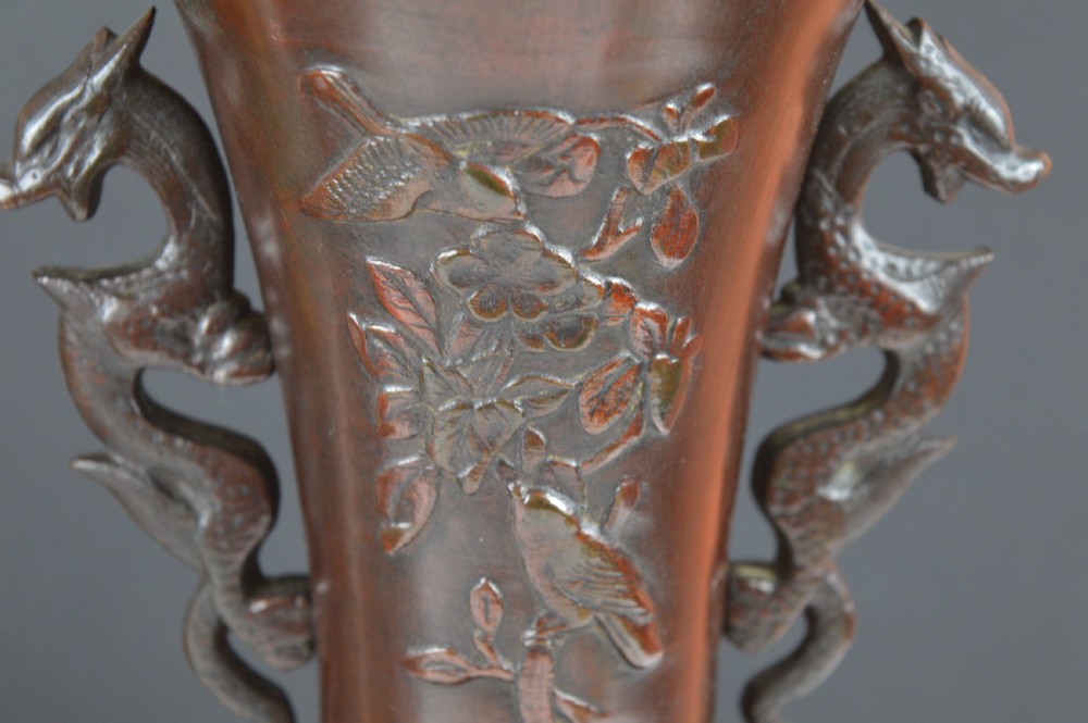A cast dark bronze baluster vase featuring dragon-form side handles, a flared rim, and relief carvings of birds perched on flowering branches. View VII