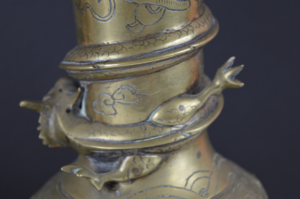 An antique brass baluster vase decorated with high-relief coiled dragons around the neck and body alongside engraved cloud patterns. View IX