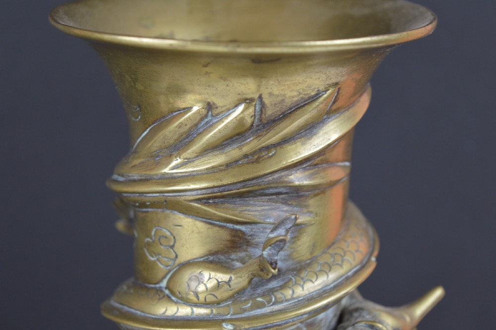 An antique brass baluster vase decorated with high-relief coiled dragons around the neck and body alongside engraved cloud patterns. View X