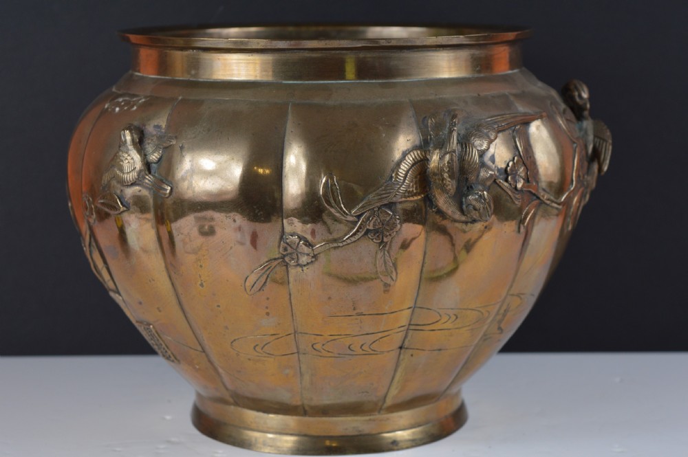 A heavy 19th-century Chinese bronze vessel featuring a lobed body adorned with raised relief carvings of birds and floral branches.