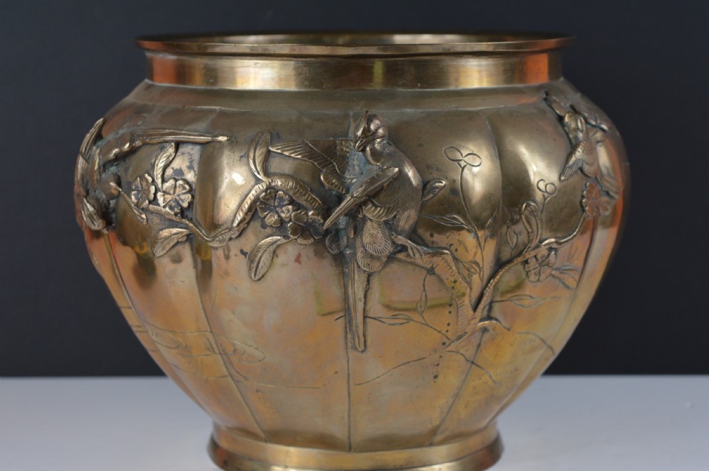 A heavy 19th-century Chinese bronze vessel featuring a lobed body adorned with raised relief carvings of birds and floral branches. View III