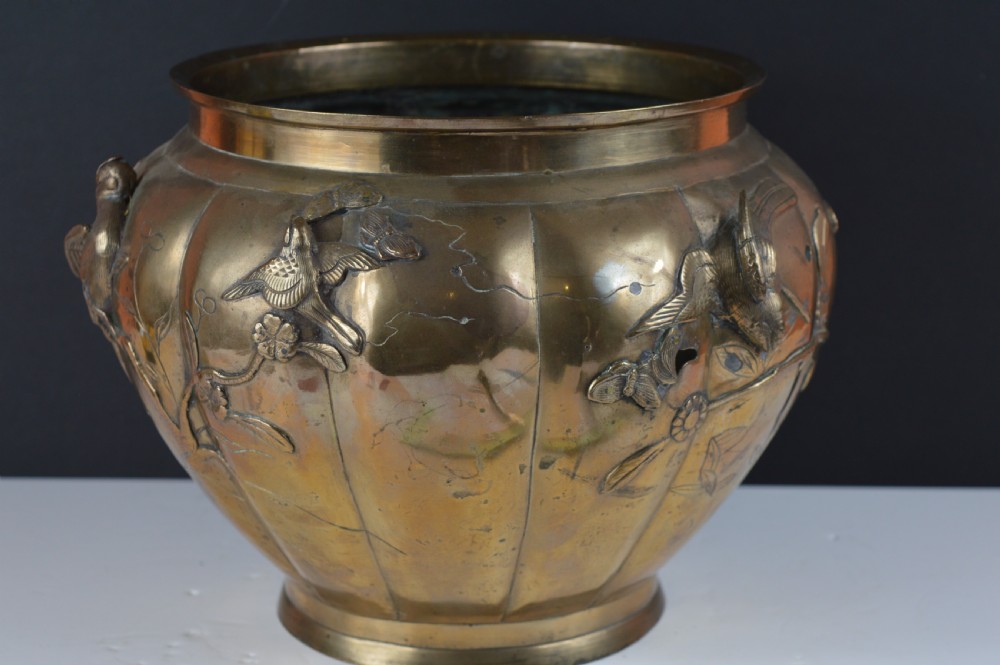 A heavy 19th-century Chinese bronze vessel featuring a lobed body adorned with raised relief carvings of birds and floral branches. View V