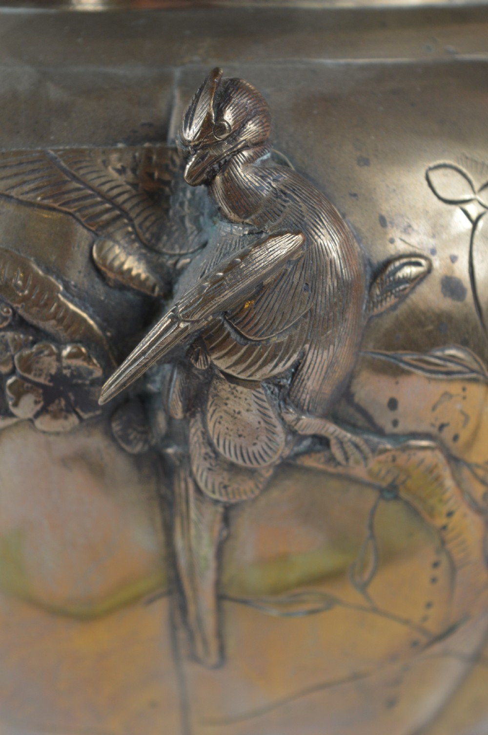 A heavy 19th-century Chinese bronze vessel featuring a lobed body adorned with raised relief carvings of birds and floral branches. View X