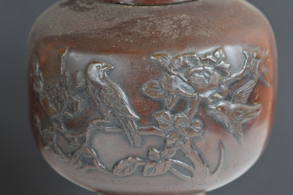 A dark brown patinated bronze vase with relief carvings of birds and flora, featuring flared rims and two stylized handles. View II