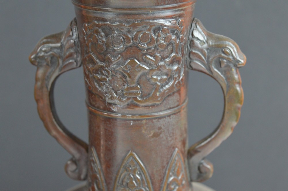 A dark brown patinated bronze vase with relief carvings of birds and flora, featuring flared rims and two stylized handles. View IV