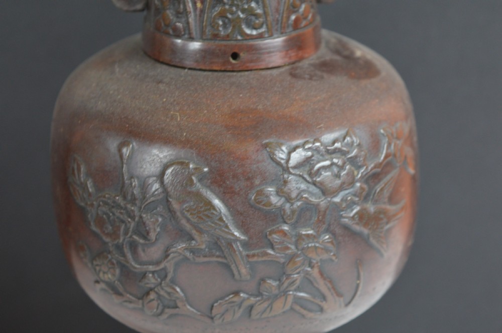 A dark brown patinated bronze vase with relief carvings of birds and flora, featuring flared rims and two stylized handles. View VI