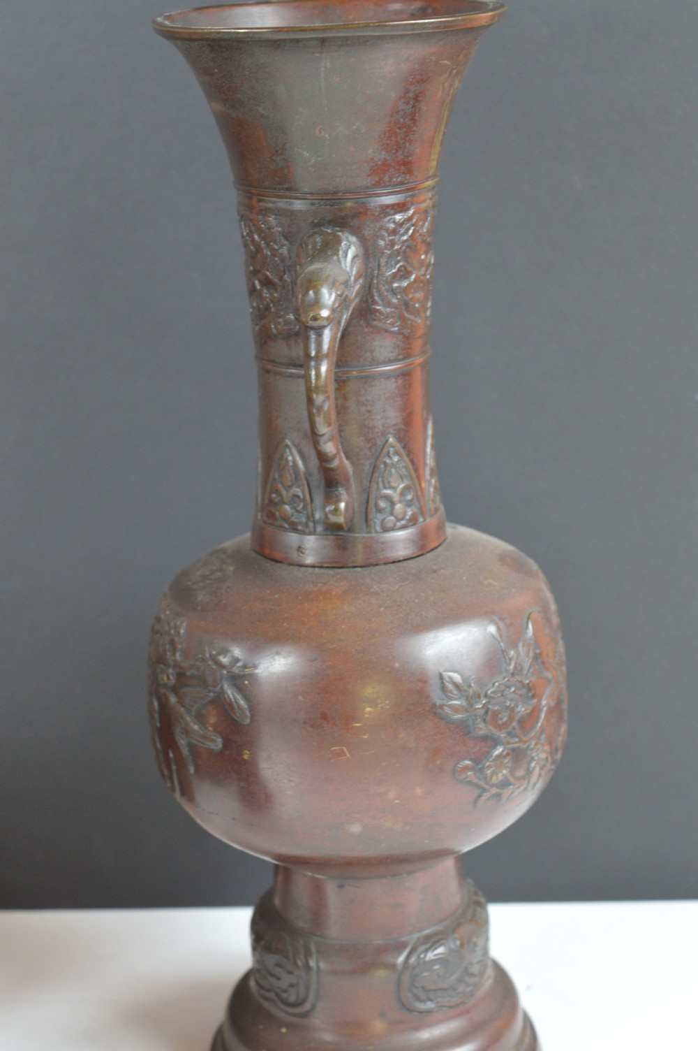 A dark brown patinated bronze vase with relief carvings of birds and flora, featuring flared rims and two stylized handles. View IX