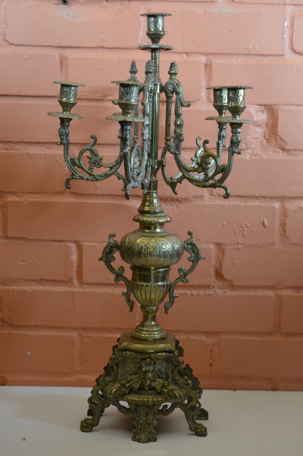 An ornate nineteenth-century French brass six-light candelabrum featuring elaborate scrollwork arms, an urn-shaped central column, and a cast footed base.