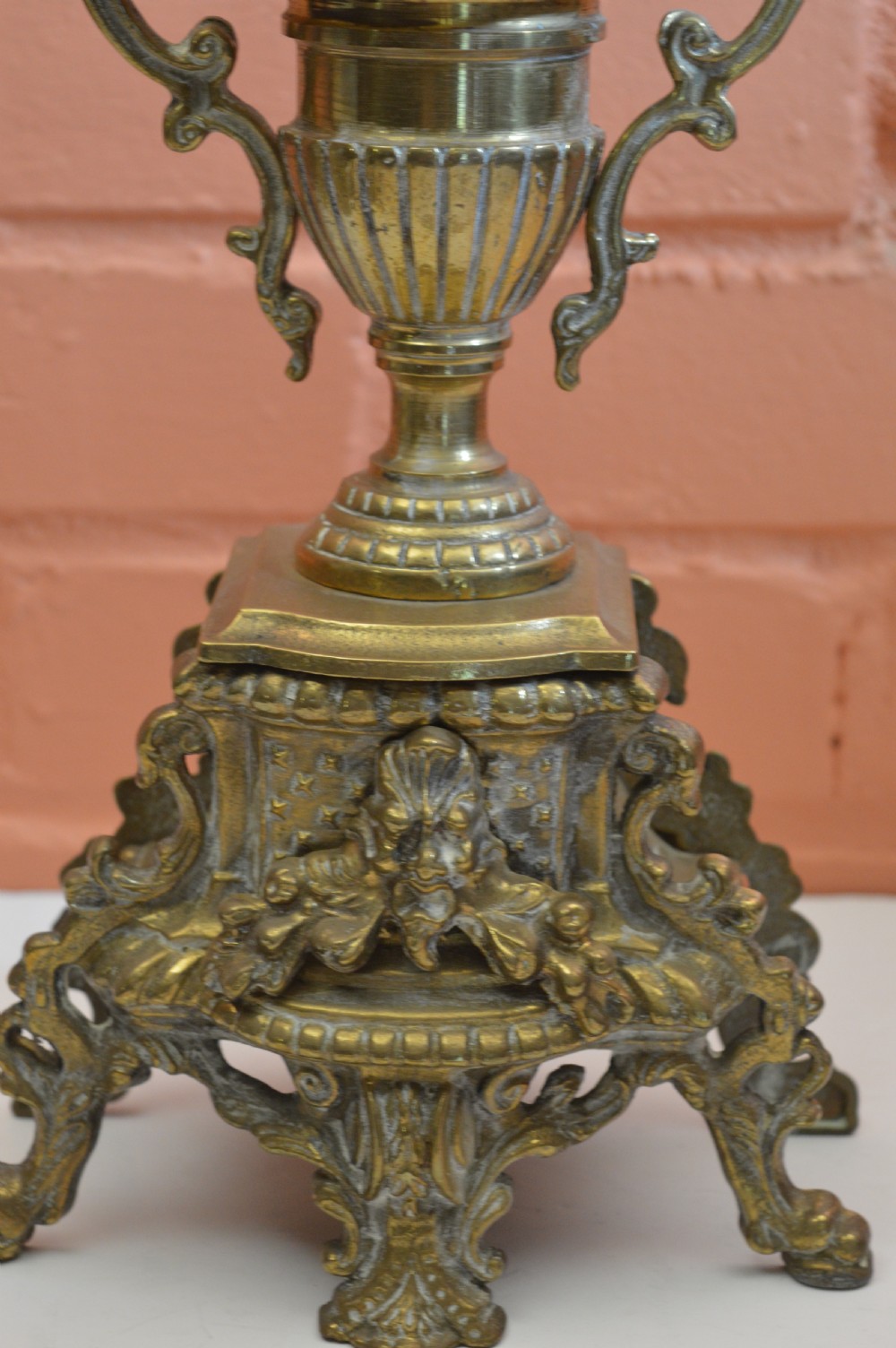 An ornate nineteenth-century French brass six-light candelabrum featuring elaborate scrollwork arms, an urn-shaped central column, and a cast footed base. View II