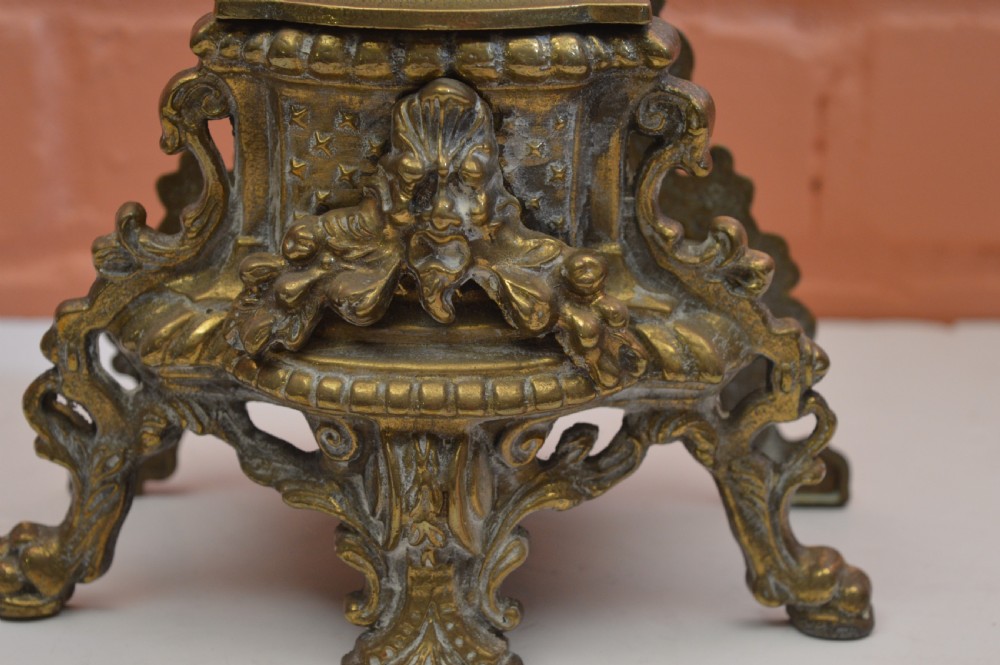 An ornate nineteenth-century French brass six-light candelabrum featuring elaborate scrollwork arms, an urn-shaped central column, and a cast footed base. View VII