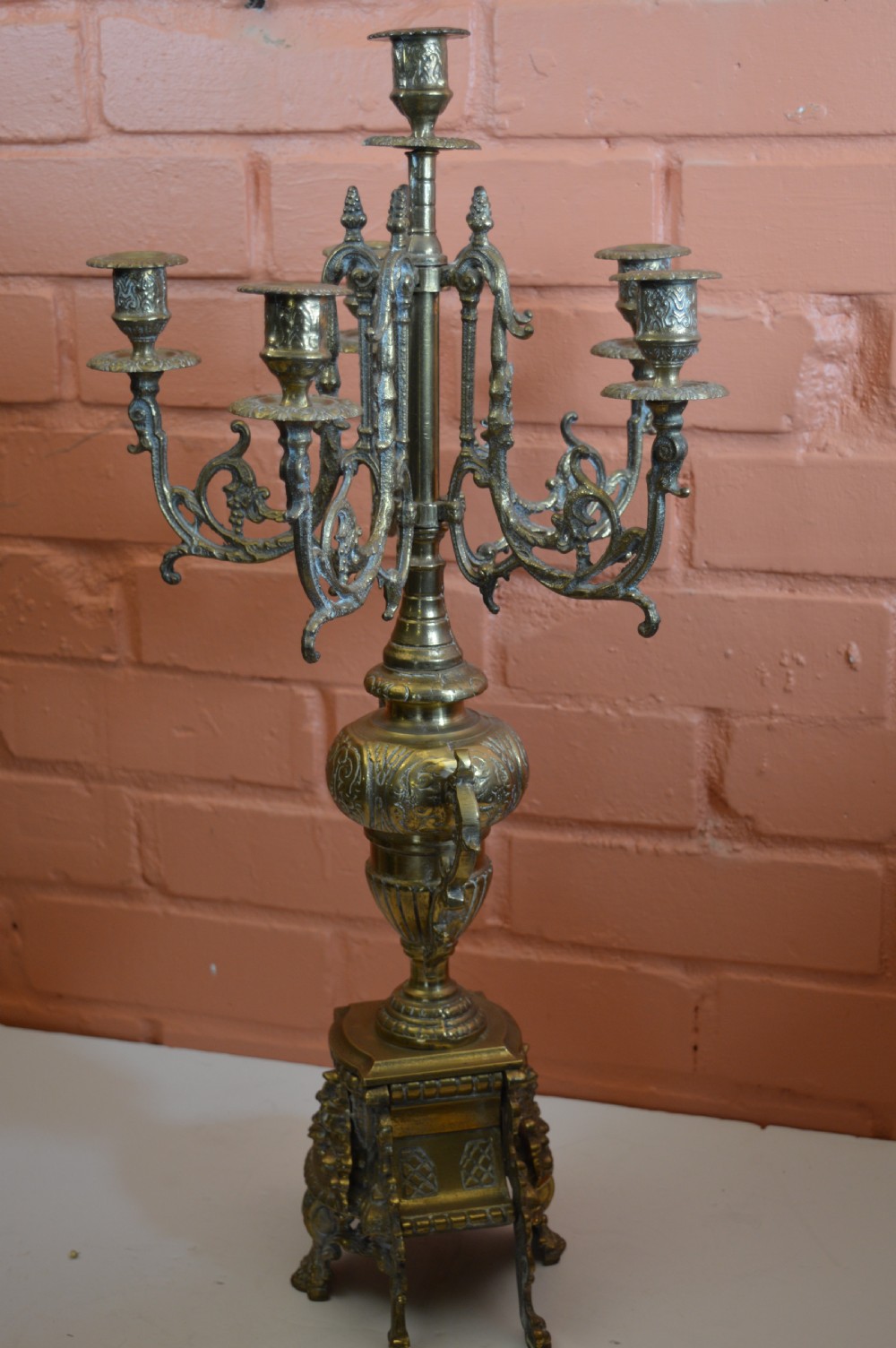 An ornate nineteenth-century French brass six-light candelabrum featuring elaborate scrollwork arms, an urn-shaped central column, and a cast footed base. View VIII