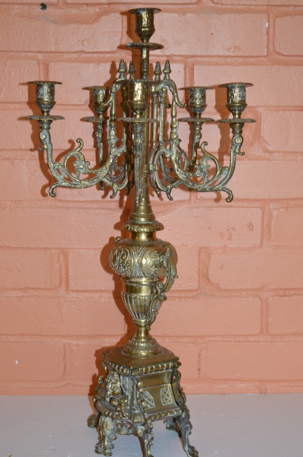 An ornate nineteenth-century French brass six-light candelabrum featuring elaborate scrollwork arms, an urn-shaped central column, and a cast footed base. View X