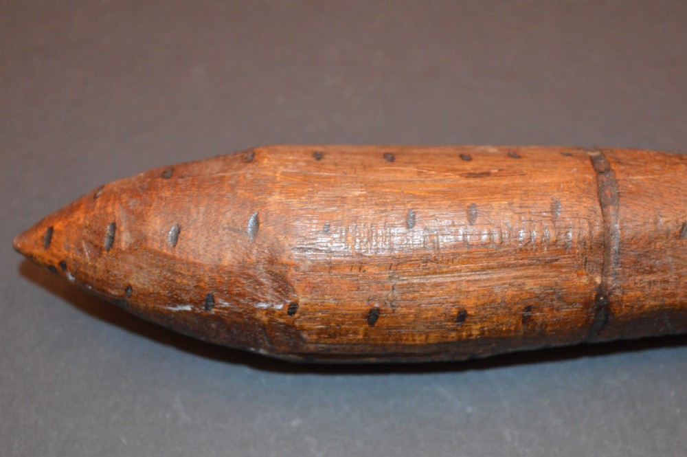 A pair of 19th-century carved Australian Aboriginal hardwood throwing clubs with pointed ends and incised dot decoration laid on a dark surface. View VI