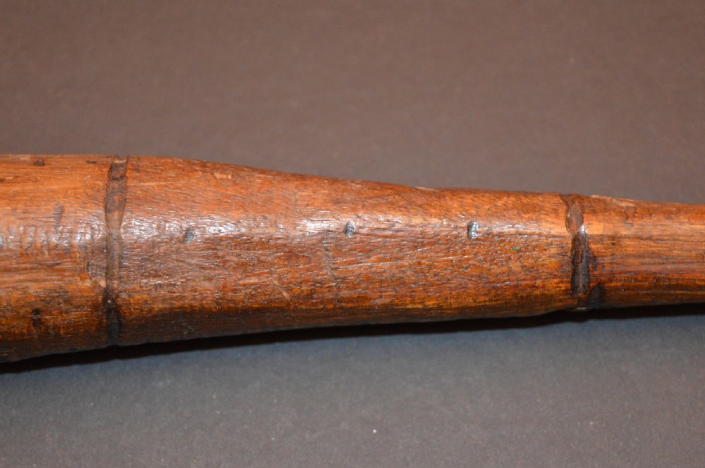 A pair of 19th-century carved Australian Aboriginal hardwood throwing clubs with pointed ends and incised dot decoration laid on a dark surface. View VII