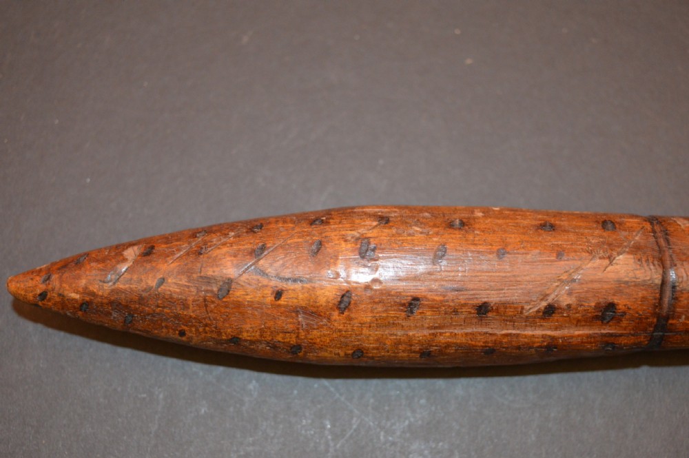 A pair of 19th-century carved Australian Aboriginal hardwood throwing clubs with pointed ends and incised dot decoration laid on a dark surface. View VIII