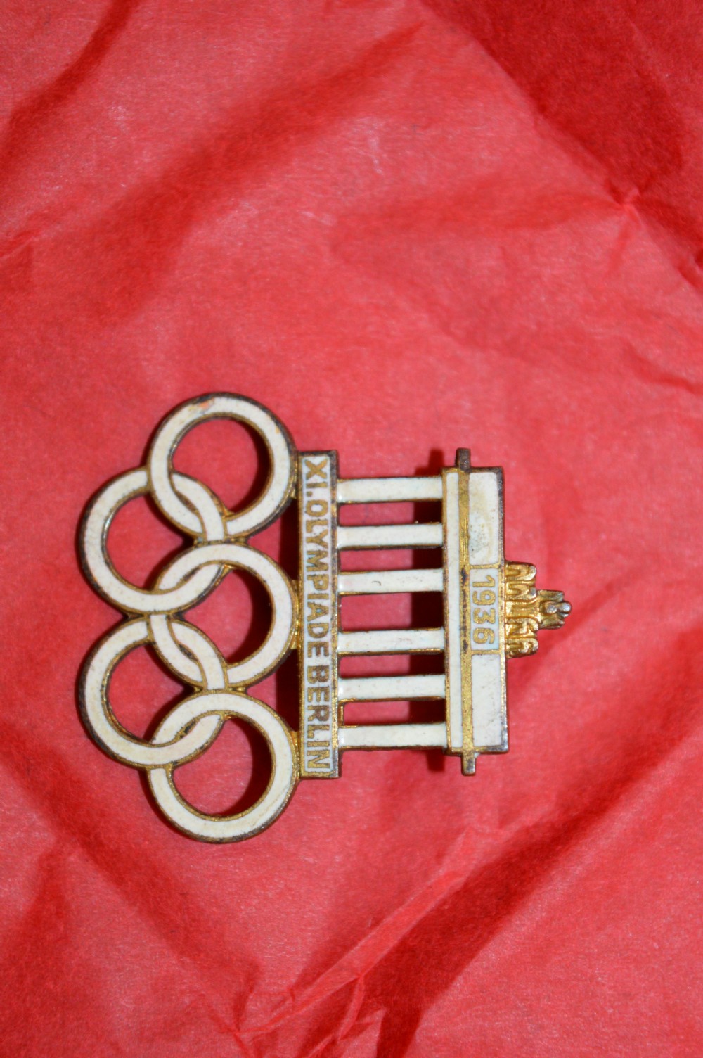A 1936 Berlin Olympic Games enamel visitor badge featuring the Brandenburg Gate above five interconnected Olympic rings. View VIII