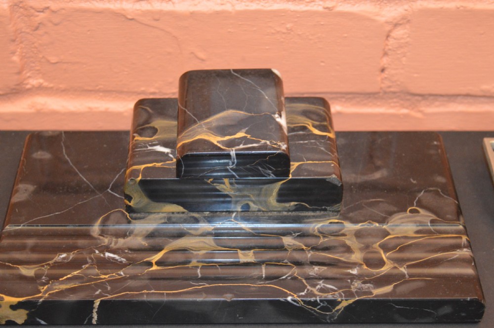 Two antique desk inkstands, one composed of black and gold veined marble with a built-in pen groove, and the second crafted from silver-toned metal with relief detailing. View VII