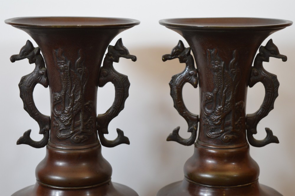 A pair of patinated dark brown Chinese bronze altar vases featuring sculpted dragon handles and low-relief carvings of birds and floral motifs. View II