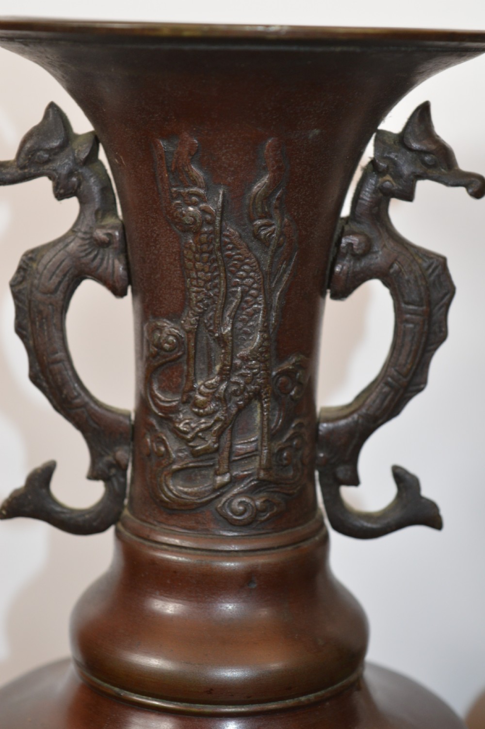 A pair of patinated dark brown Chinese bronze altar vases featuring sculpted dragon handles and low-relief carvings of birds and floral motifs. View IV
