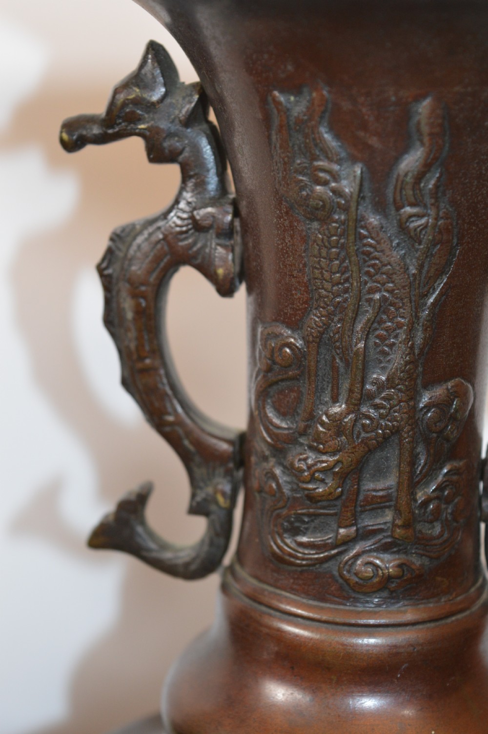 A pair of patinated dark brown Chinese bronze altar vases featuring sculpted dragon handles and low-relief carvings of birds and floral motifs. View VI