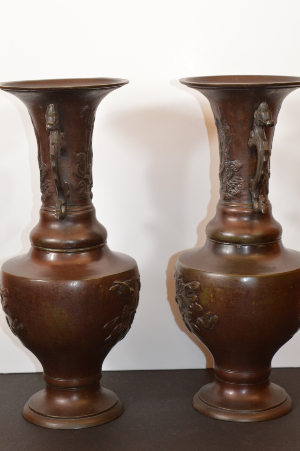 A pair of patinated dark brown Chinese bronze altar vases featuring sculpted dragon handles and low-relief carvings of birds and floral motifs. View VIII