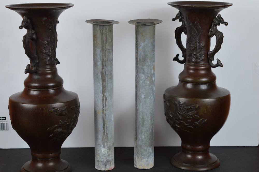A pair of patinated dark brown Chinese bronze altar vases featuring sculpted dragon handles and low-relief carvings of birds and floral motifs. View X