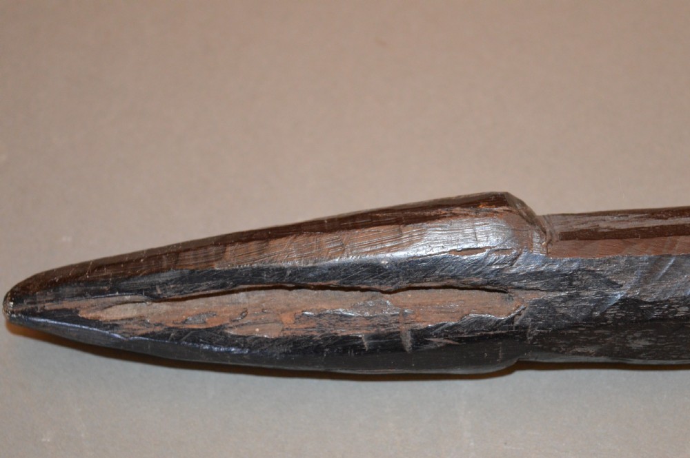 A late 19th-century Polynesian hardwood paddle club featuring a carved central ridge running along the length of its elongated blade section. View V