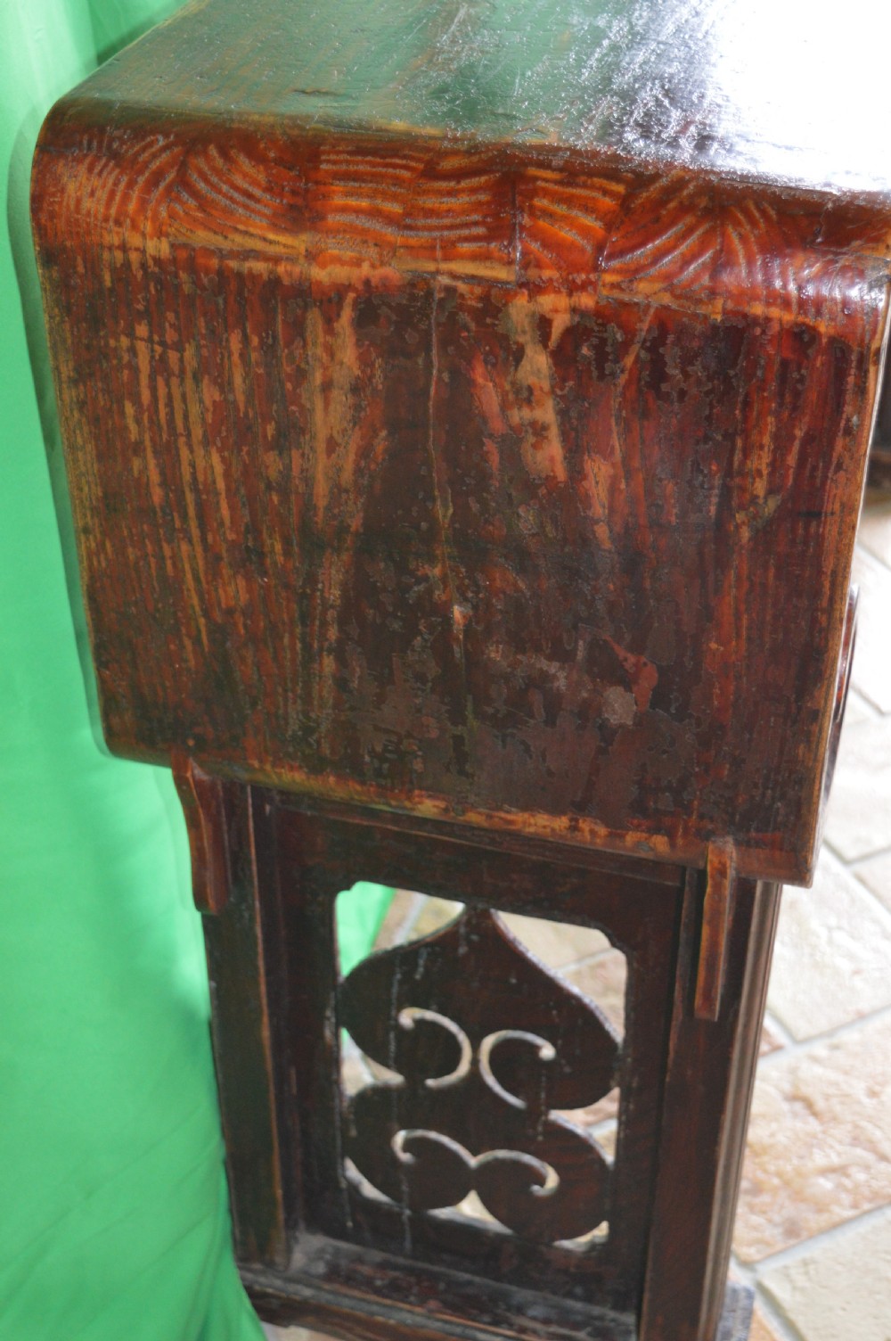 A long dark hardwood Tibetan altar table featuring a flat rectangular top supported by upright legs with prominent carved scroll terminals. View IX