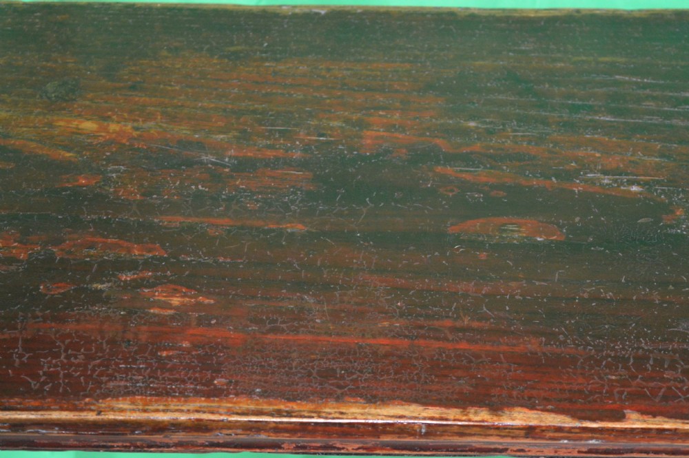A long dark hardwood Tibetan altar table featuring a flat rectangular top supported by upright legs with prominent carved scroll terminals. View XII
