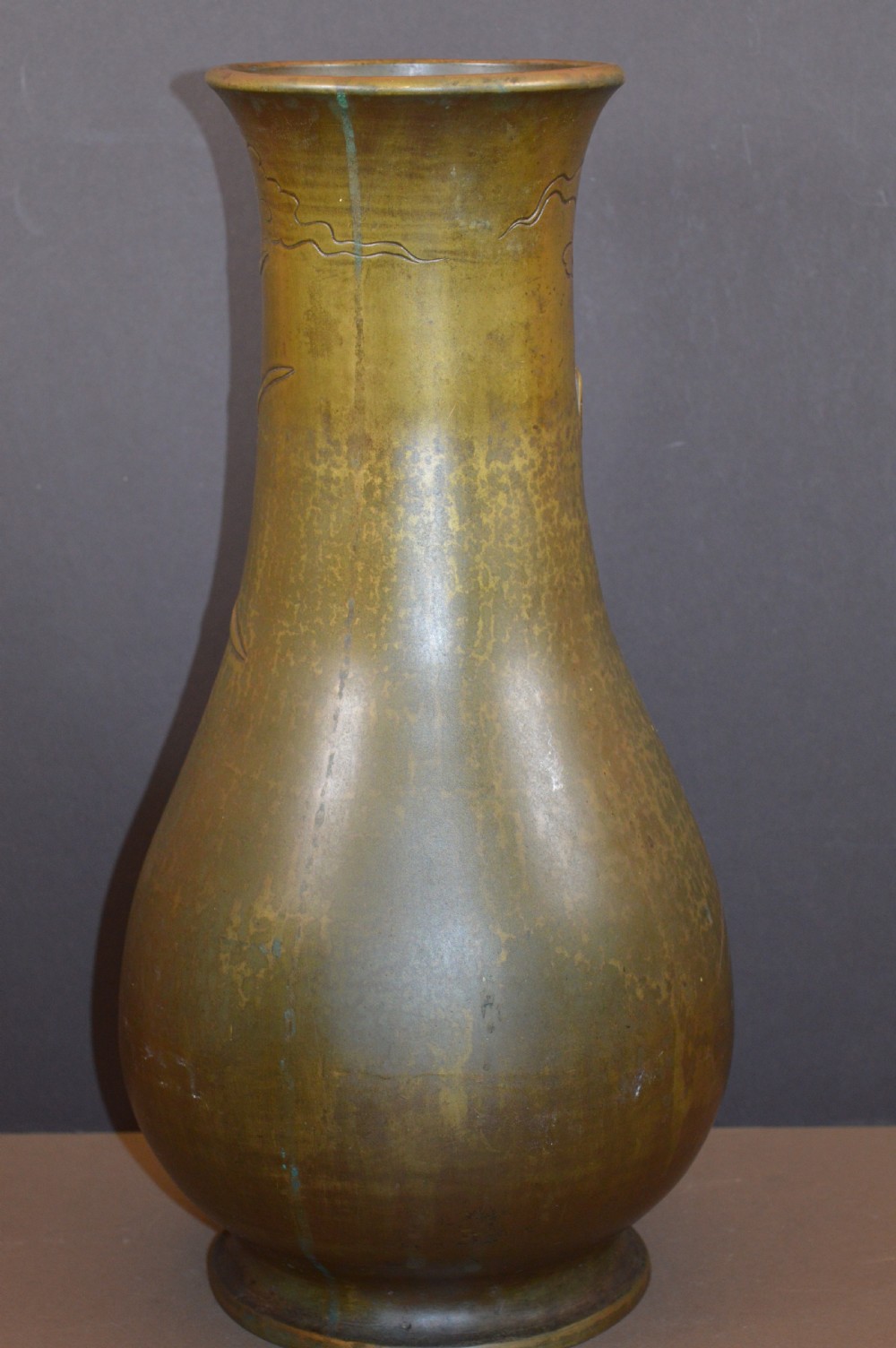 A tall baluster-shaped bronze vase featuring a high-relief carved dragon emerging from swirling waves and cloud motifs. View VI