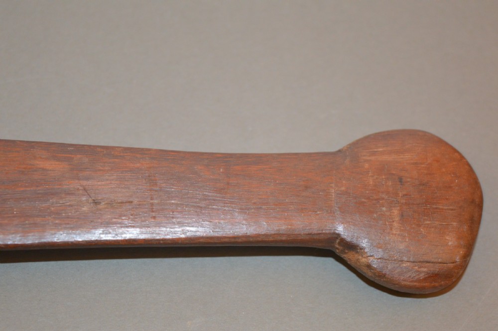 A pair of 19th-century carved Indigenous Australian wooden woomeras displaying elongated curved profiles and natural timber grain. View III