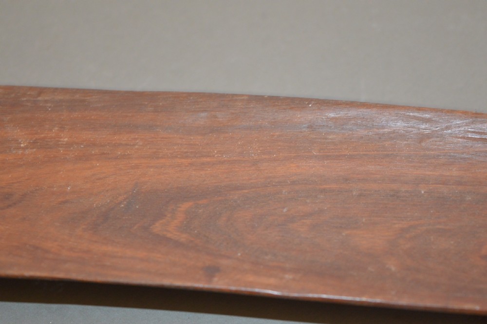 A pair of 19th-century carved Indigenous Australian wooden woomeras displaying elongated curved profiles and natural timber grain. View IV