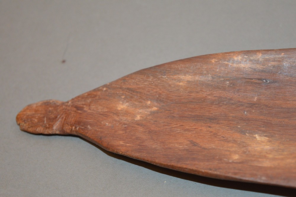 A pair of 19th-century carved Indigenous Australian wooden woomeras displaying elongated curved profiles and natural timber grain. View V