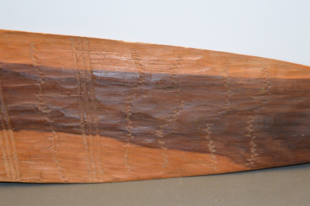 A pair of 19th-century carved Indigenous Australian wooden woomeras displaying elongated curved profiles and natural timber grain. View VIII