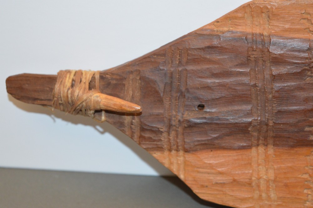 A pair of 19th-century carved Indigenous Australian wooden woomeras displaying elongated curved profiles and natural timber grain. View X