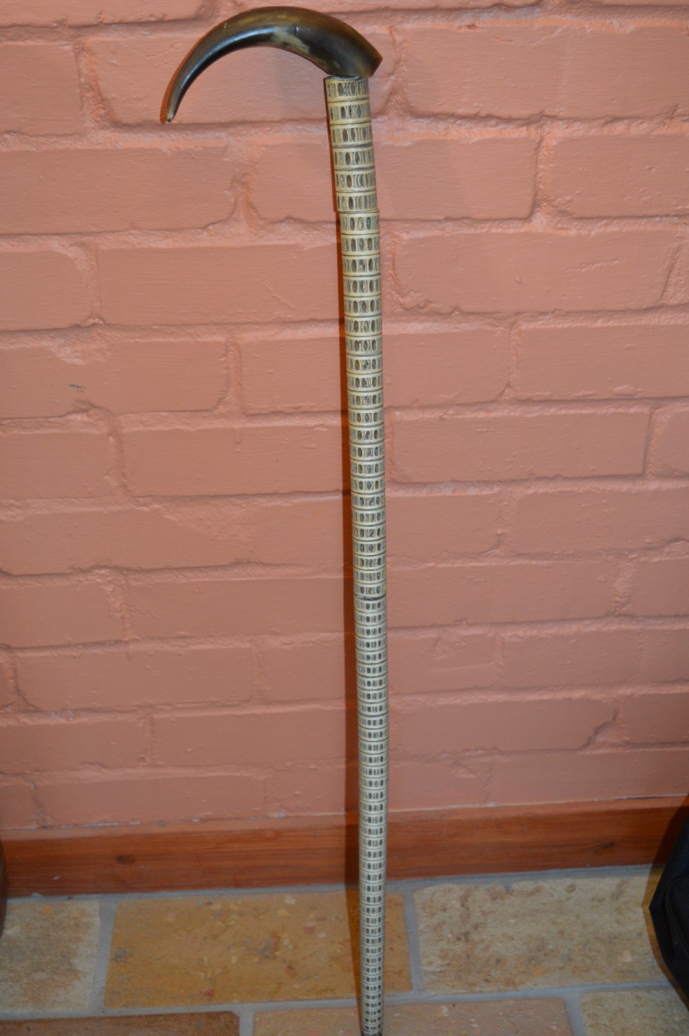 An antique Victorian walking stick featuring a shaft constructed from stacked shark vertebrae and topped with a curved dark horn handle.