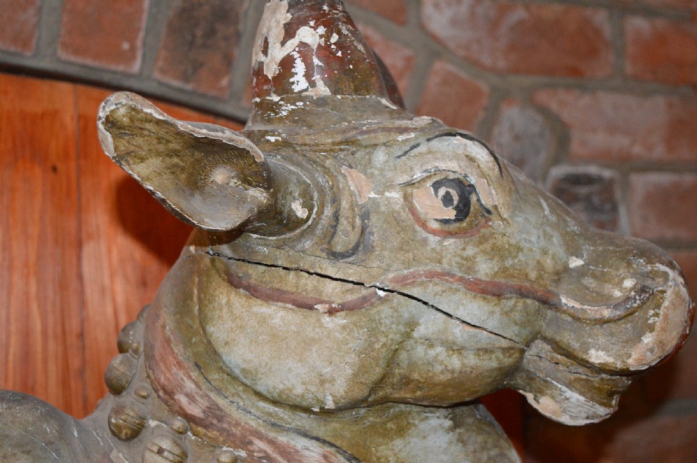 A large antique carved wooden Nandi bull statue featuring worn polychrome paint and decorative carved bells around its neck. View III