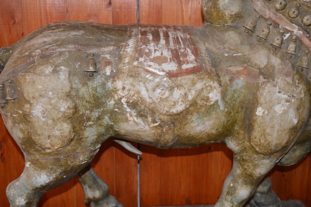 A large antique carved wooden Nandi bull statue featuring worn polychrome paint and decorative carved bells around its neck. View VIII