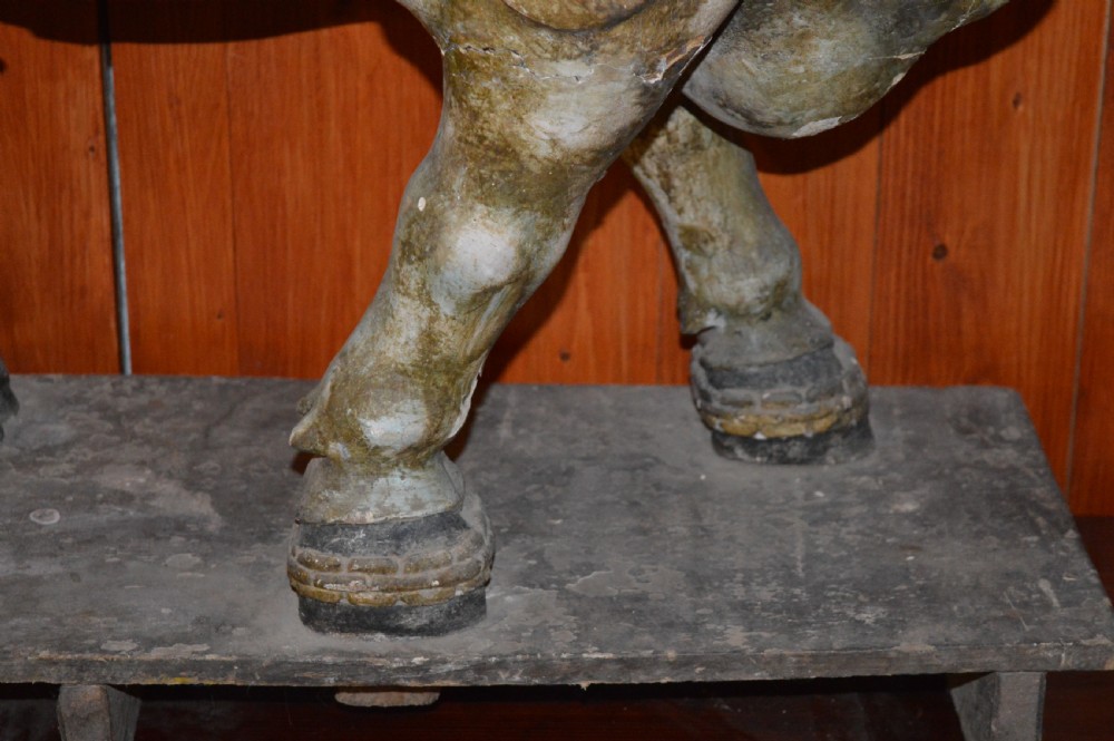 A large antique carved wooden Nandi bull statue featuring worn polychrome paint and decorative carved bells around its neck. View XI