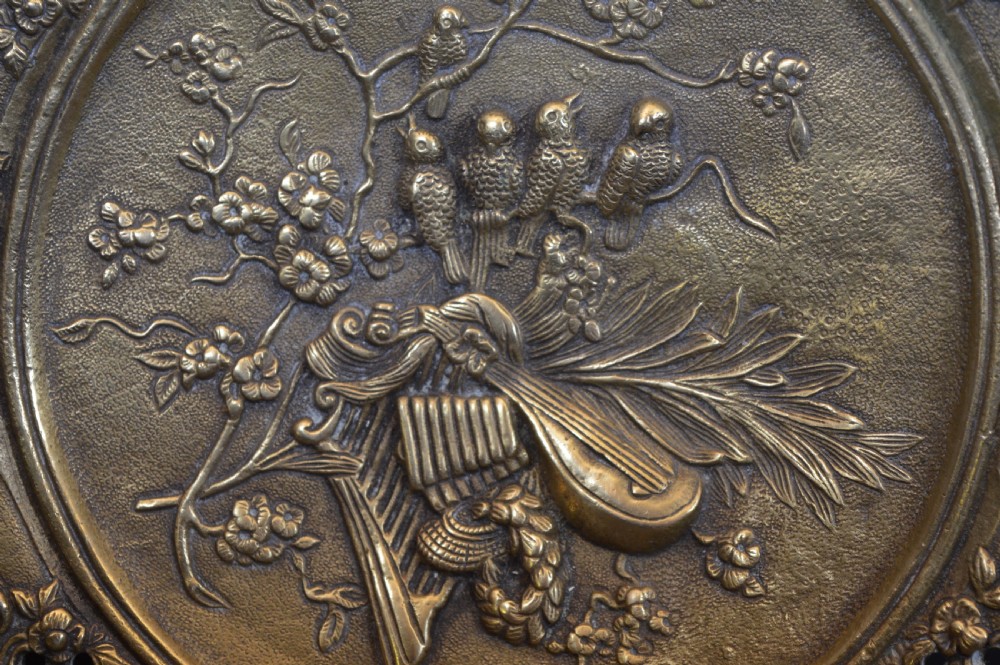 A cast bronze decorative centrepiece plate featuring a high-relief central scene with birds and musical instruments surrounded by an openwork lattice border and scroll handles. View III