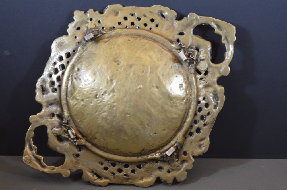 A cast bronze decorative centrepiece plate featuring a high-relief central scene with birds and musical instruments surrounded by an openwork lattice border and scroll handles. View XI