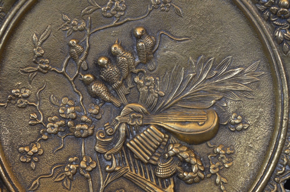 A cast bronze decorative centrepiece plate featuring a high-relief central scene with birds and musical instruments surrounded by an openwork lattice border and scroll handles. View XIII
