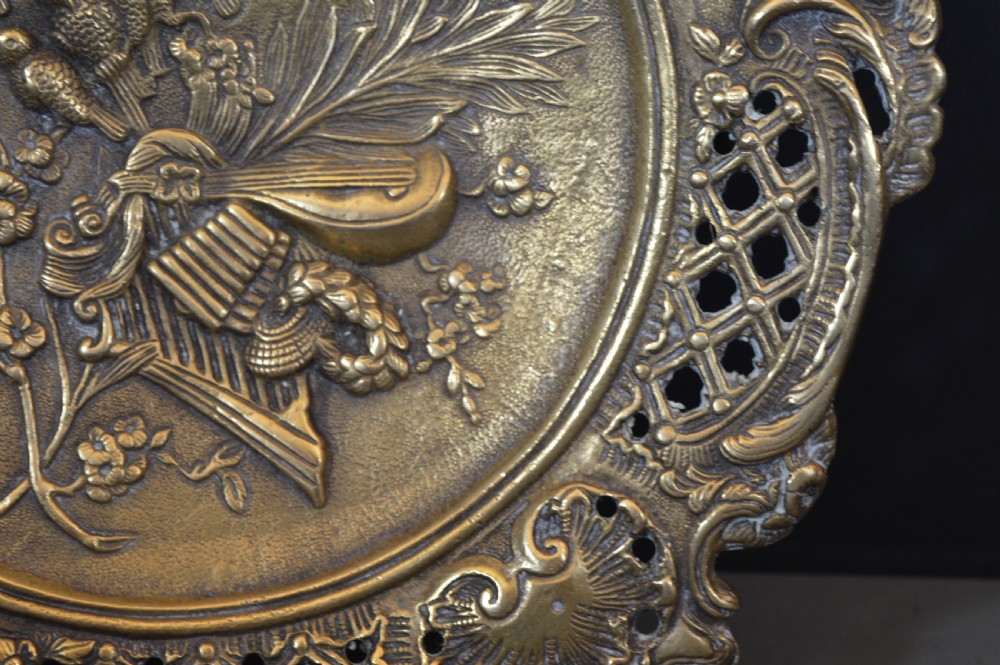 A cast bronze decorative centrepiece plate featuring a high-relief central scene with birds and musical instruments surrounded by an openwork lattice border and scroll handles. View XIV