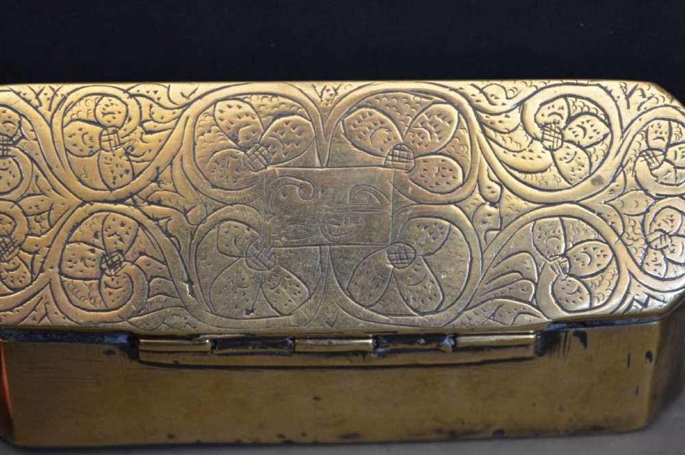 An elongated Georgian brass tobacco box featuring hand-engraved floral motifs, canted corners, and a hinged lid. View II