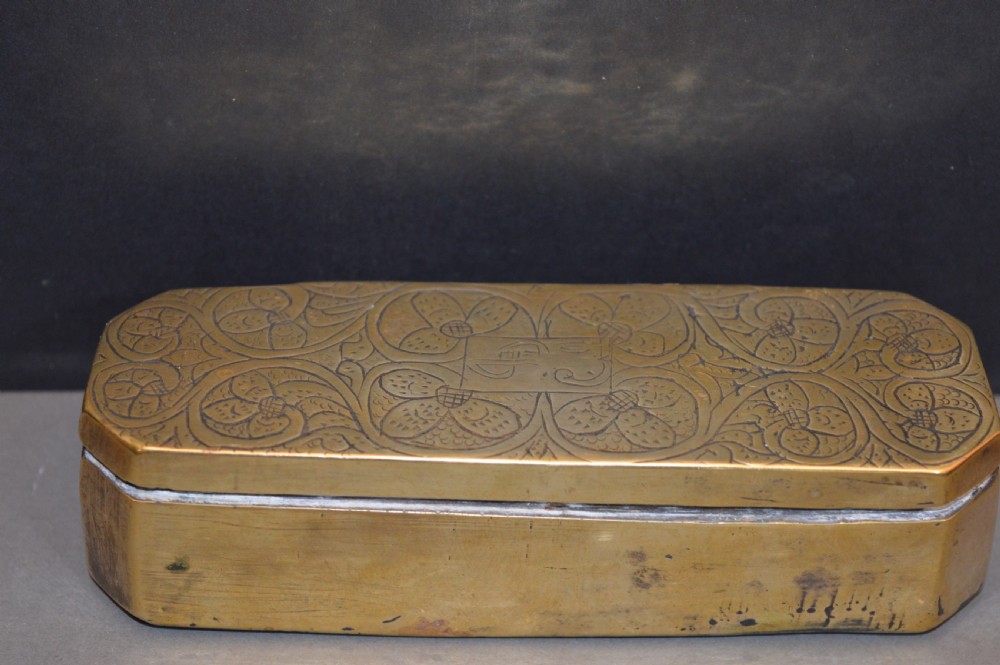 An elongated Georgian brass tobacco box featuring hand-engraved floral motifs, canted corners, and a hinged lid. View IV