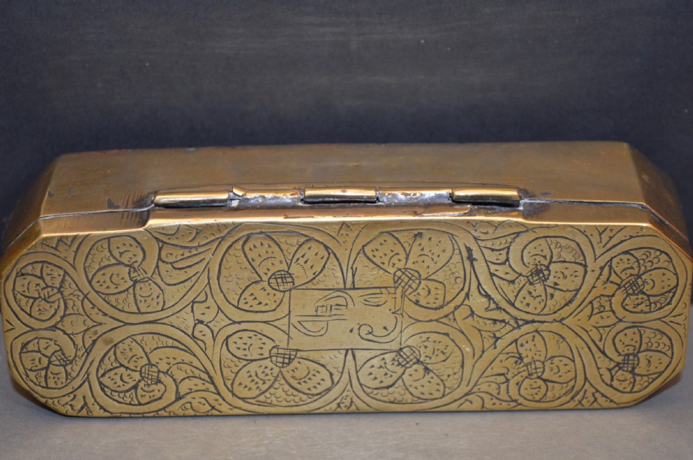 An elongated Georgian brass tobacco box featuring hand-engraved floral motifs, canted corners, and a hinged lid. View V