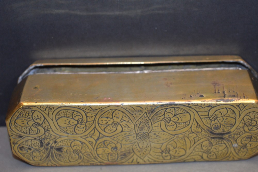 An elongated Georgian brass tobacco box featuring hand-engraved floral motifs, canted corners, and a hinged lid. View VII